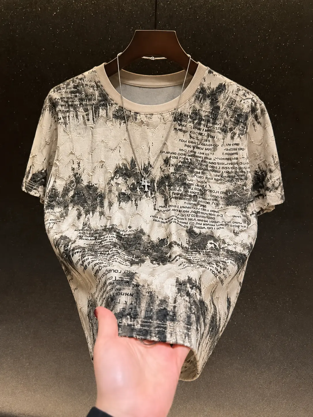 One men’s crew neck short sleeve T shirt with a hole detail and heat pressed silver lettering; urban casual style with all over English print paired with glitter powder for a distressed texture. Soft, skin friendly fabric—ideal for city men’s everyday com
