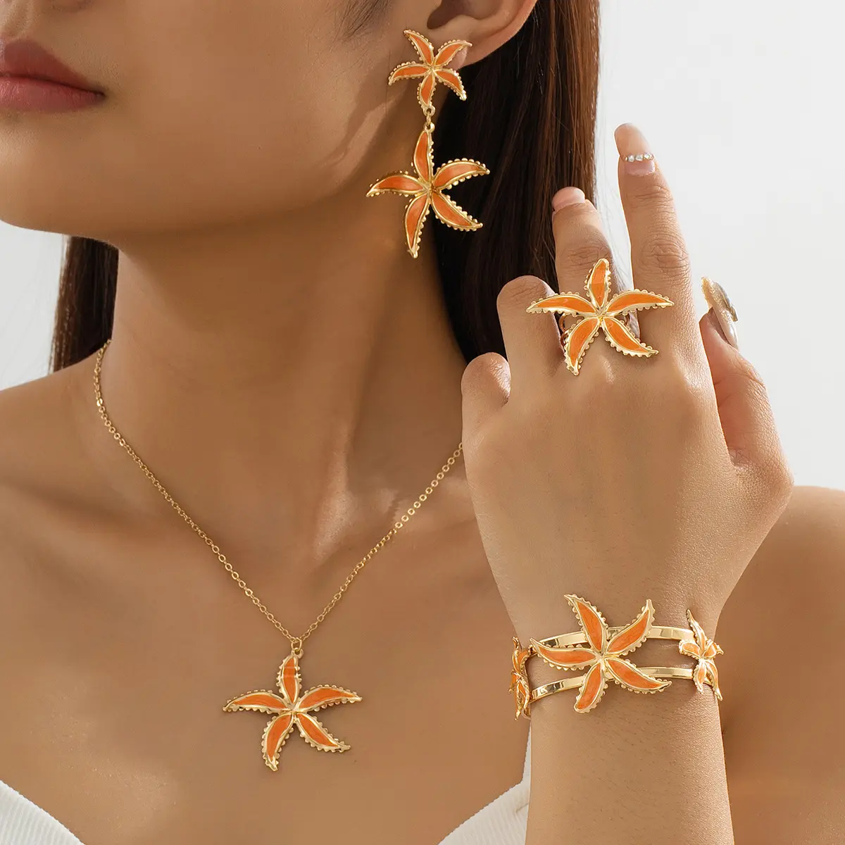 A set of trendy orange starfish pendant necklace, earrings, bracelet, and ring suitable for holiday wear as a gift