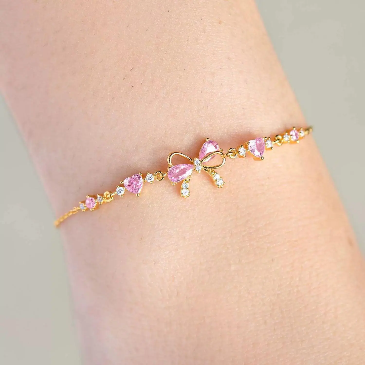 Women's Adjustable Gold-Silver Tone Bow Bracelet - Elegant Bow & Heart Design, Shimmering Blush Pink Crystal Heart Accents, Customizable Fit, Versatile Tennis-Style Jewelry for Office Attire, Gifting, Adults