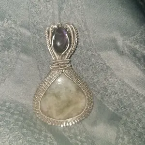 Stunning, one of a kind, Seraphinite cabochon wire wrapped pendant with small labradorite accent stone. Pendant comes with a silver chain.