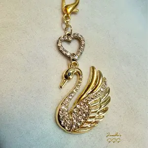 Brass tone, rhinestone swan with heart bead bag charm