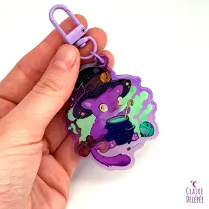 Cute witch and its frog familiar making a potion keychain
