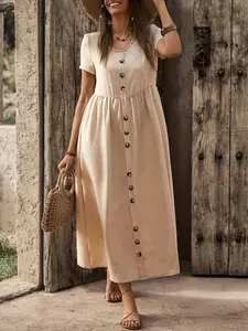A women's light beige short-sleeve long dress, featuring a round neck design and short-sleeve style, with a row of buttons on the front, French countryside style, suitable for casual settings such as rural vacations and outdoor picnics.