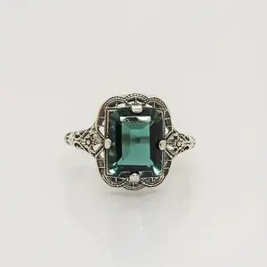 This Victorian-inspired synthetic emerald ring features an openwork lace-patterned design that recreates the jewelry craftsmanship of the vintage era, making it an elegant, slightly luxurious antique-style ring for women.