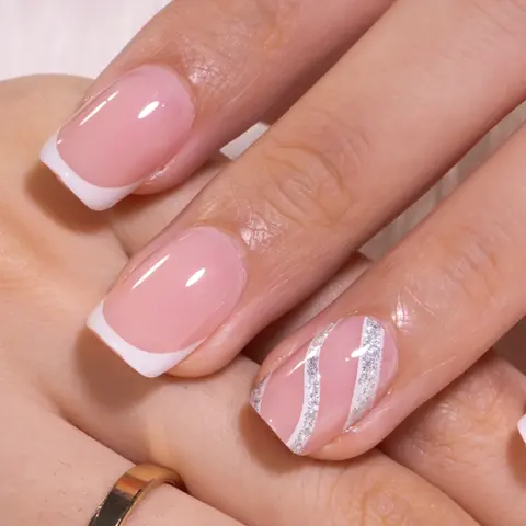 An elegant short square French manicure featuring soft nude pink nails with crisp white tips, paired with a delicate silver and white swirl accent design on the ring finger, creating a timeless and sophisticated look perfect for any occasion.