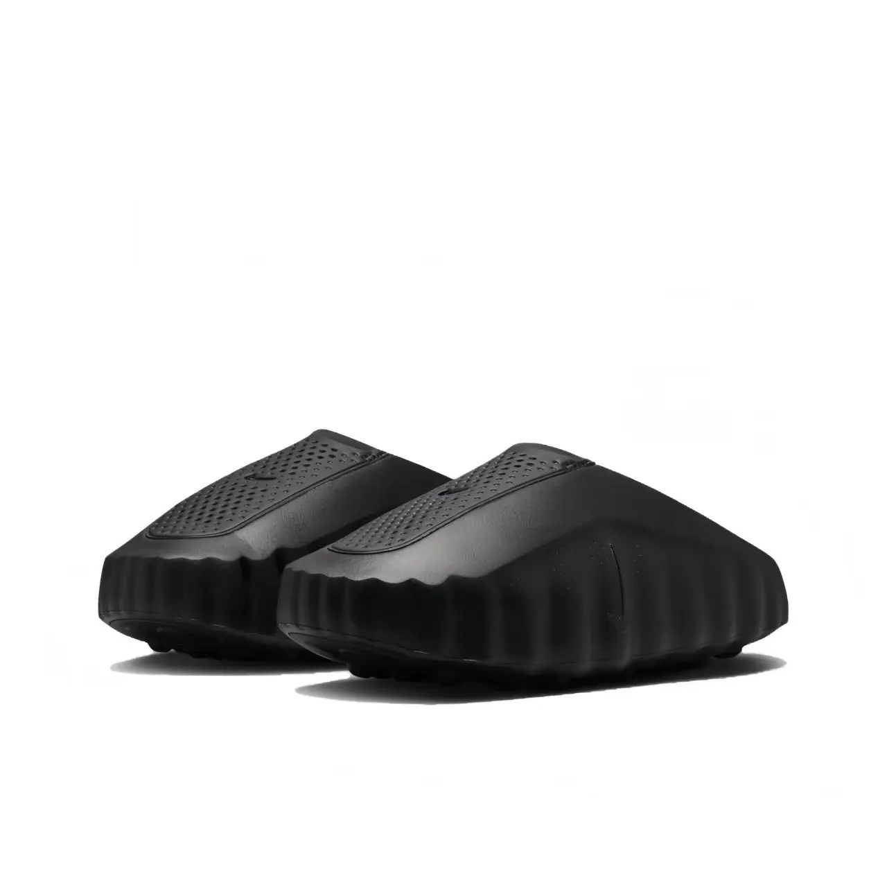 Retro black sandals featuring perforated upper, chunky ribbed sole, and slip-on closure, perfect for summer and casual everyday looks.