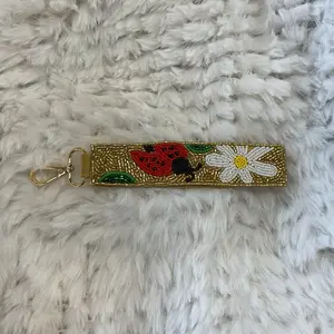 Handmade Wristlet Keychain with Floral and Ladybug Design on Soft Fur Background