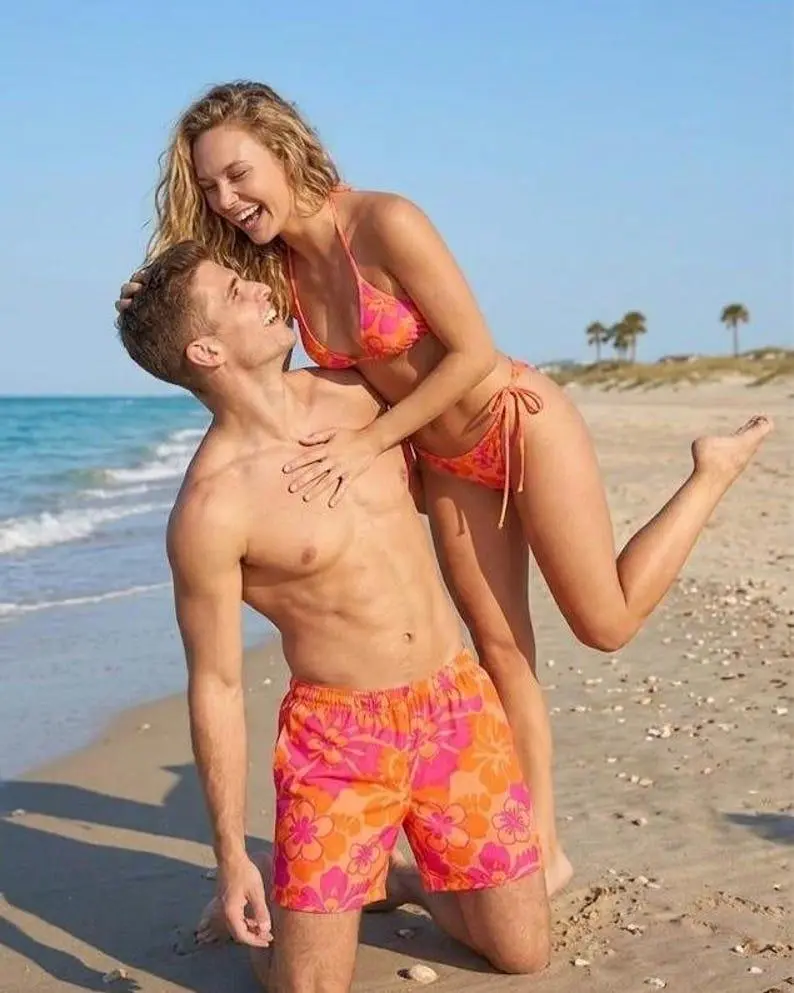 [Hot] Matching tropical floral swimwear for couples—perfect for honeymoons or romantic anniversary gifts—featuring a vibrant pink bikini and Hawaiian-style shorts.