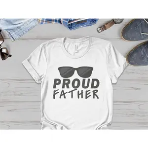 Women's Father's Day celebration and fatherhood pride Graphic T-Shirt - Short Sleeve Crew Neck Regular Fit Casual Wear | Soft & Breathable Fabric, Durable Print, Everyday Comfort, Machine Washable, casual and modern Flat lay lifestyle setup with men's