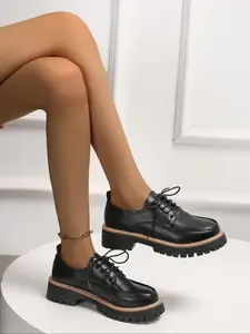 A pair of fashionable and versatile women's British style patent leather round-toe platform thick-soled loafers. Deep heel design with comfortable lace-up closure. Stylish and casual women's shoes for daily wear.