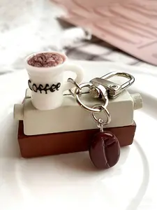 A fun keychain pendant in the shape of a coffee cup and coffee beans, featuring a playful and cute style. It is suitable for coffee lovers to hang on their bags or keys in daily life, adding personality and a sense of life to leisure scenes such as commut