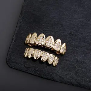 Top and bottom cross grillz made with durable gold-plated metal, adorned with clear CZ stones in a cross pattern. Includes silicone molding bars for an adjustable, comfortable fit on most teeth sizes.