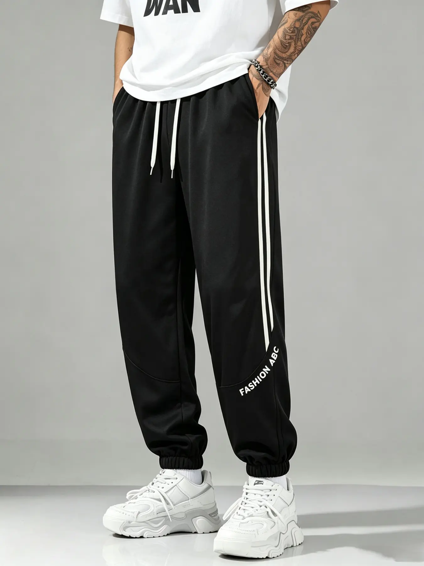 Men’s joggers/sweatpants with side double stripes, loose fit, elastic waistband with drawstring; vertical stripe letter print jogging pants; retro jogger sweatpants; men’s long pants with a fluid drape and comfortable feel for everyday wear; elastic cuffs