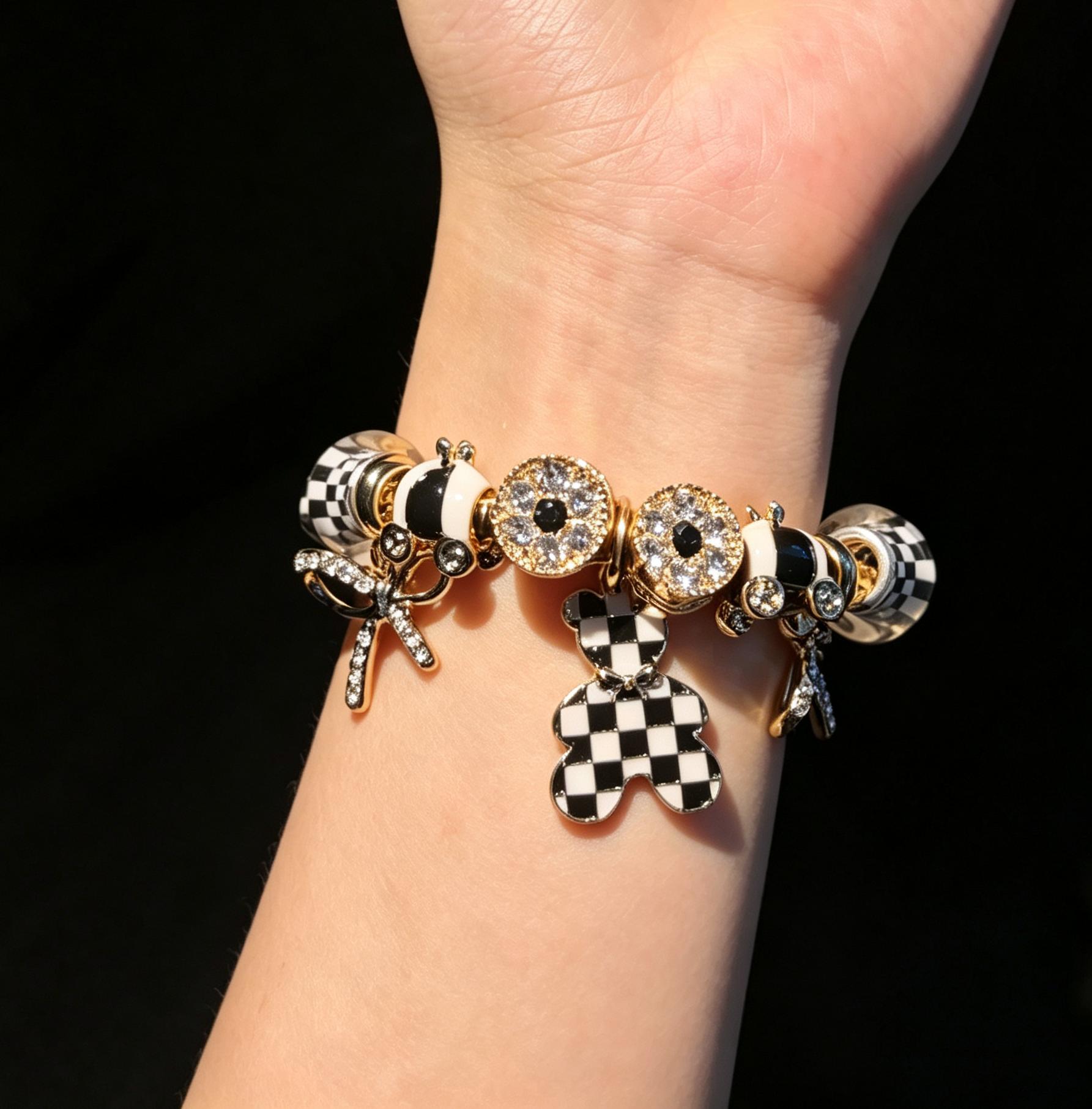 Women’s black-and-white plaid pendant bracelet with a gold-tone snake chain and beads, featuring a bow and crystal rhinestones—an elegant, luxurious jewelry gift. Women’s black-and-white plaid pendant bracelet with a gold-tone snake chain and beads, featuring a bow and crystal rhinestones—an elegant, luxurious jewelry gift.