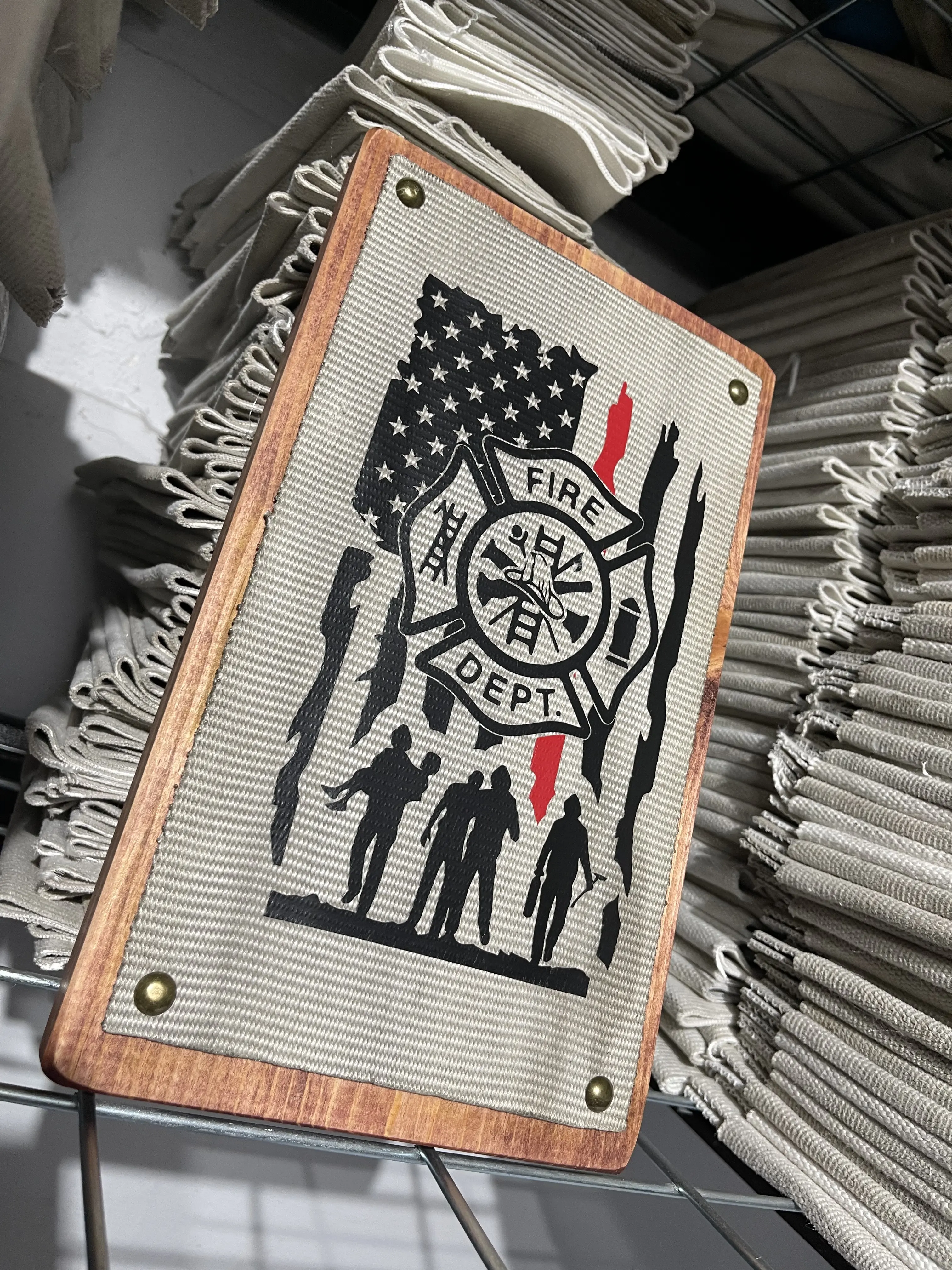 Fire Hose Thin Red Line Flag Sign with firefighter figures. The sign is made from used/decommissioned fire hose and the graphic is made with heat pressed vinyl. The sign is 100% made in the USA from a small shop called Crafty American