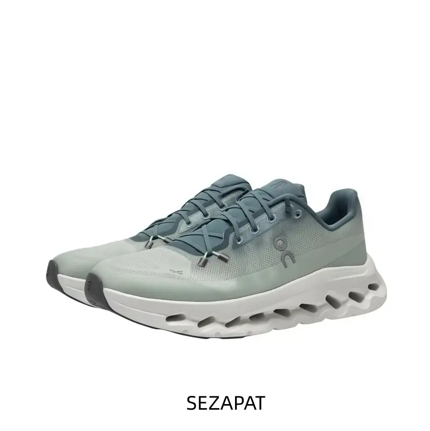 Ice Sage And Deep Navy Technical Running Shoe Featuring A Hollow-Core Segmented Midsole, A Silver-Grey Anatomical Logo, And A Black Rubber Toe Guard