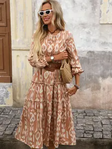 A women's long-sleeve layered cake dress in warm brown with geometric totem patterns, featuring a vintage casual style with an ethnic vibe, suitable for relaxed everyday occasions such as city strolls, caf gatherings, or light vacations.