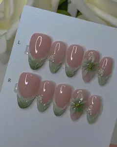 Soft sage green French press-on nails with glossy nude base, 3D floral petals and pearl gold accents, fresh spring Korean botanical aesthetic nail art set perfect for feminine nature lovers