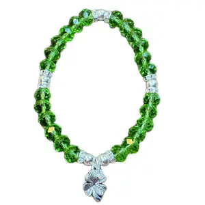 Green crystal, clear crystal beaded elastic stretch bracelet with four-leaf clover charm.