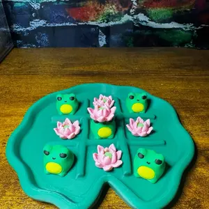 Tic Tac Toad - Fun Game with Green Toad and Pink Lotus Pieces on a Lily Pad-shaped Board
