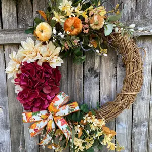 Fall inspired floral and ribbon grapevine wreath. Orange, cream, yellow, cranberry, green, gold