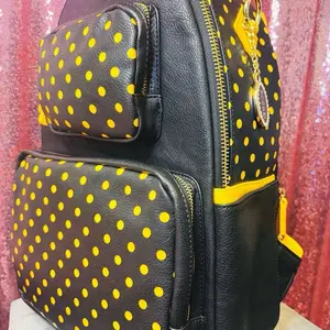 Our Bumble Bee is perfect for spring & summer! Score! AKA “The Perfect Game Day Bag” Our Black with Yellow Polka Dots, Zippered Pocket, and Organizer Features with buckles to apply and access charms. PomPom fluff available for purchase.