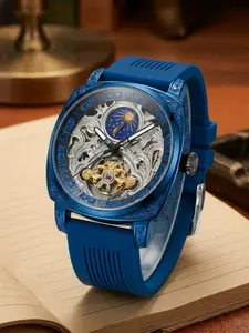 A blue-toned, openwork carved pattern casual and fashionable business style student automatic mechanical watch with moon phase and blue rubber strap.