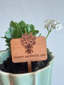 This beautifully crafted ceramic planter features a soft sage glaze with subtle vertical fluting for a timeless, elegant look. Nestled inside is a living flowering plant, paired with a laser-engraved wooden "Happy Mother's Day" keepsak.