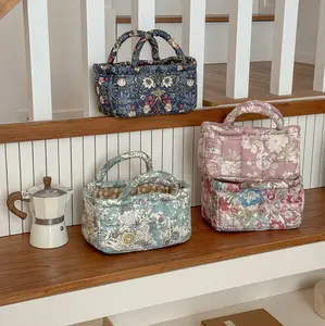 Small quilted storage basket with large floral pattern, vintage floral design, wear-resistant molded construction, handheld desktop design, portable—ideal for storing small miscellaneous items.