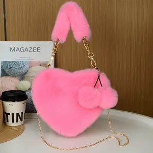 Women's Plush Heart-Shaped Shoulder Bag with Pom-Pom Charm - Soft Faux Leather Handbag with Zipper Closure and Wrist Strap, a cozy winter accessory suitable for everyday wear and special occasions,