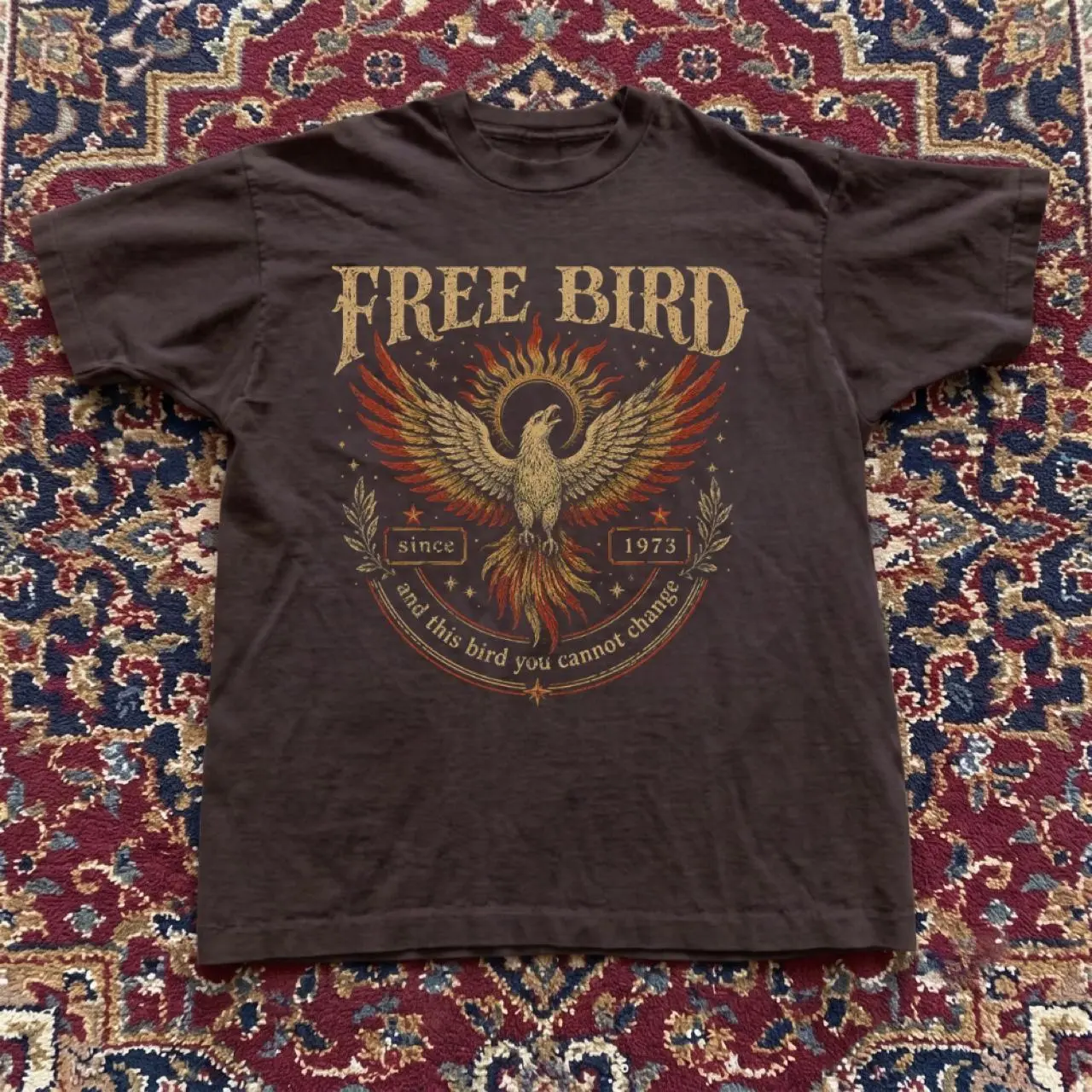 Free Bird T-shirt with graphic of a phoenix with the words 'FREE BIRD', 'since 1973' T-shirt Fabric Fit