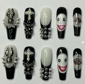 Edgy gothic nail set with creepy clown faces, spikes, chains, and silver cross accents in black and white, perfect for bold Halloween horror looks.