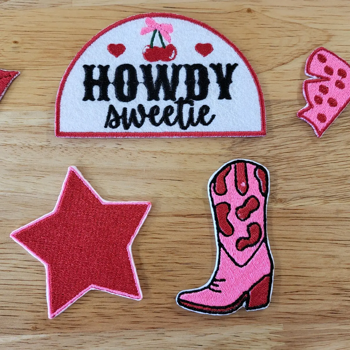 Set of 5 embroidered iron on patches with a Howdie Sweetie, boot, lips, bow, and star patch in teal and copper or pink and red.