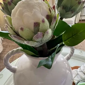 Elegant White Flower in a White Vase with Green Leaves and Purple Tips