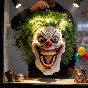 Classic clown latex mask, green exploding wig, red round nose, pale base, black arched eyebrows, wide grin, yellow teeth. Suitable for Halloween cosplay, horror parties, carnival parties, and short video shooting. One size fits all adults.