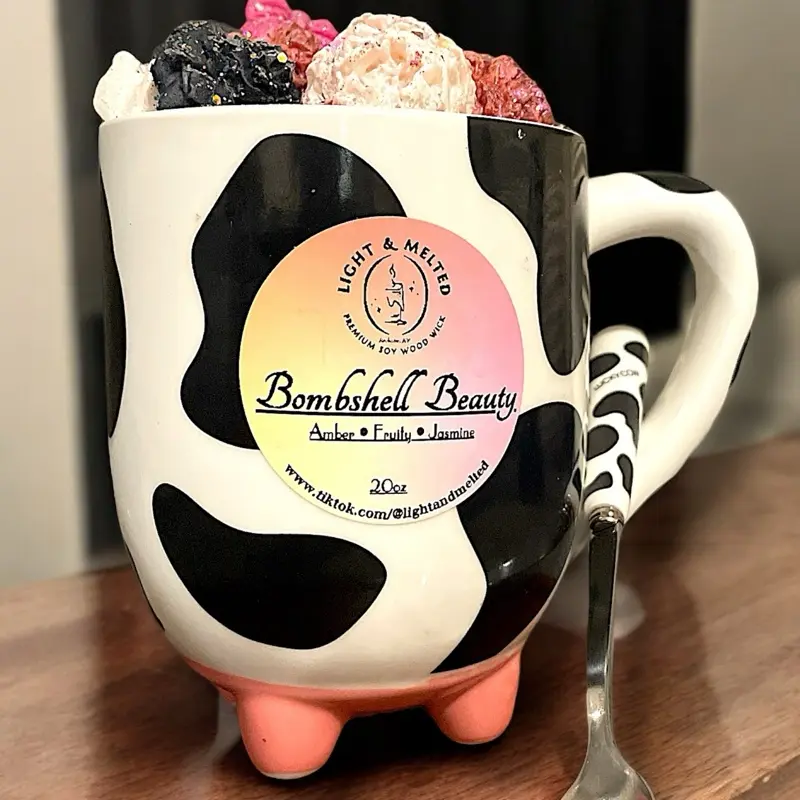 20oz “ANY SCENT U WANT!” soy wax candle w/ an extra 5oz’s of wax melts on top, in a Dishwasher & Microwave safe ceramic cow print mug, paired with a metal cow print spoon. Scented with Amber, Fruity, & Jasmine. Burn time~100hrs (depends on use) Decor