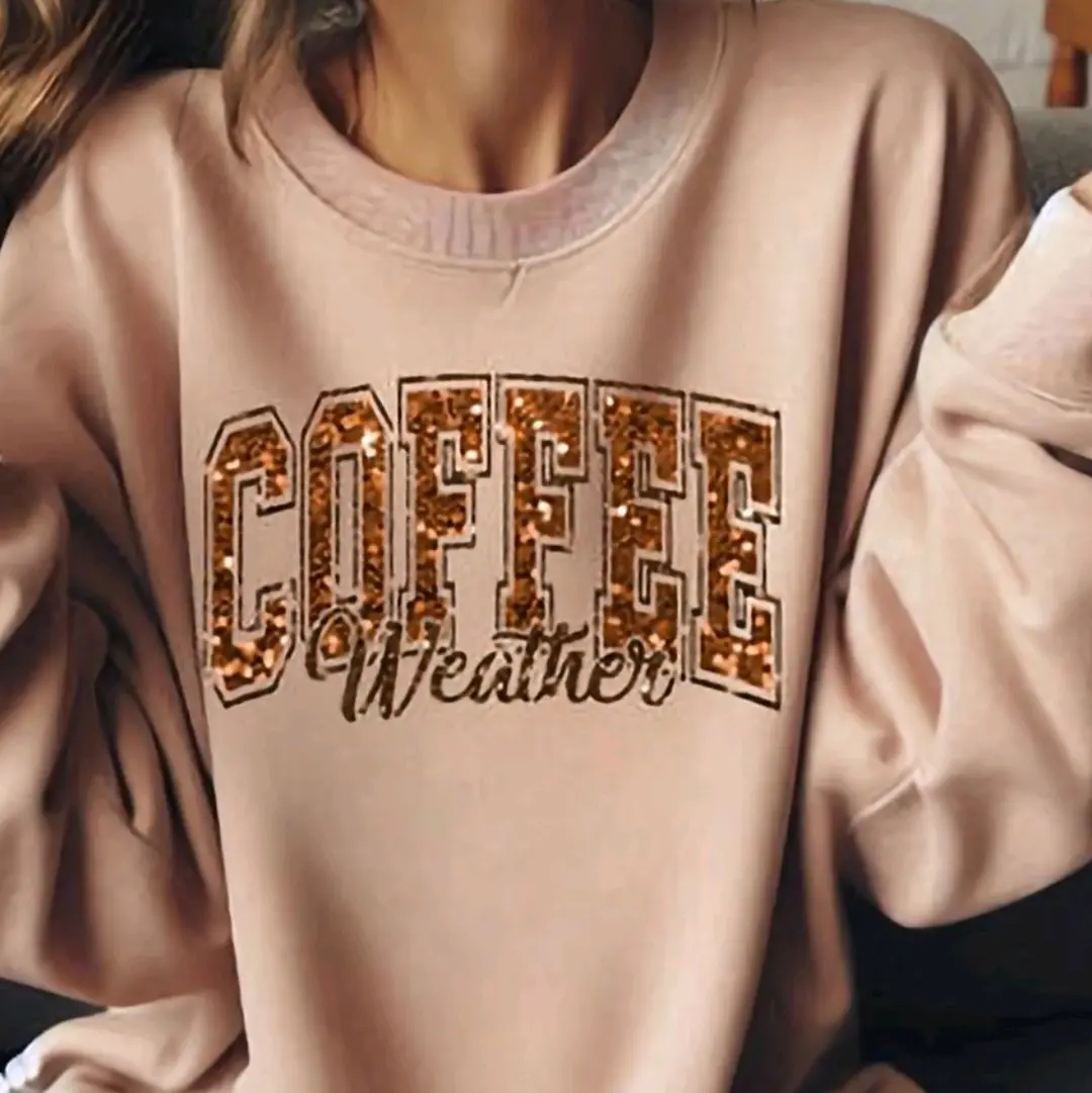 Womans Gildan fall crewneck sweater with the words Coffee weather screen printed in real glitter onto the front.