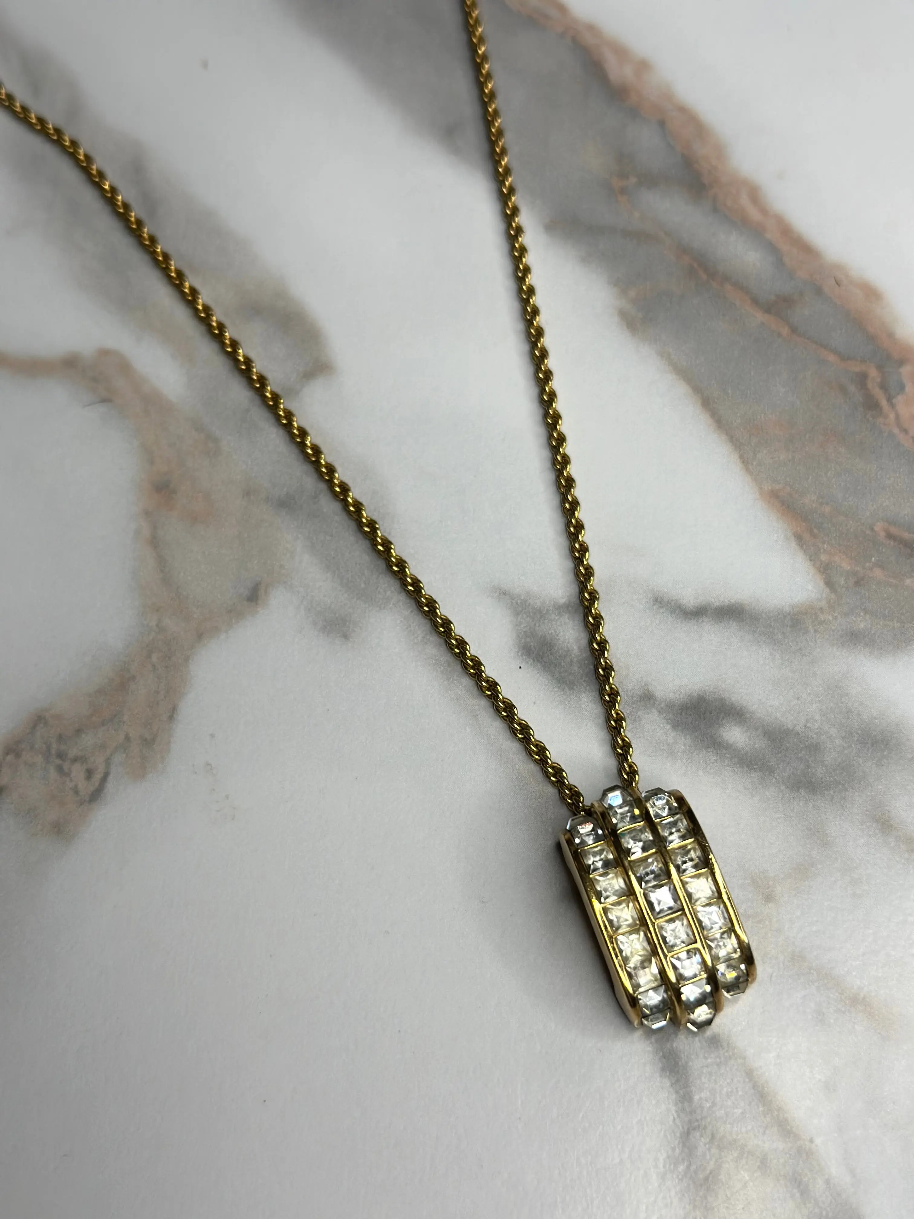 Pre-owned Christian Dior vintage necklace features a gold tone chain and a cylindrical pendant