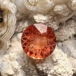 Beautiful Red Oregon Sunstone with Schiller.   Cut in a unique design with frosted edges on the pavilion   6.4 Ct, 13mm