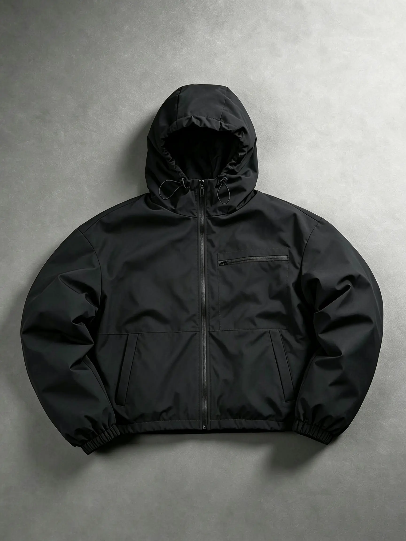 Men’s solid black functional hooded softshell jacket made from waterproof woven fabric, featuring an adjustable hood with multiple drawstrings, elastic cuffs, and a hem; suitable for hiking and camping, everyday commuting, and minimalist outdoor outfits.