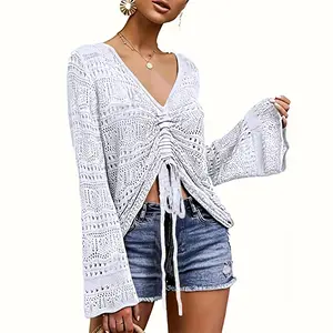 This white crochet knit top features a ruched drawstring front, V-neck, and bell sleeves, perfectly paired with denim shorts for a breezy summer look-D240229