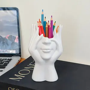 This uniquely elegant and creative multi-functional pen holder and makeup brush holder features a face-shaped design and is suitable for decorating an office desk and storing makeup brushes, cosmetics, dressing table items, pens, and other personal items.