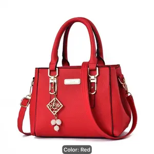 Elegant Red Handbag for Women with Gold Accents and Decorative Charm
