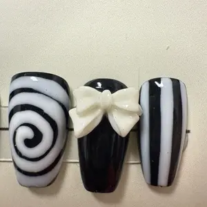 Hand Painted Halloween Nails with Black and White Swirl Design and White Bow Accent