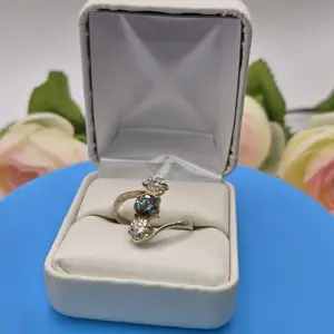 Elegant Three-Stone Ring with Blue and White Stones in Gold Tone Band Ideal for Special Occasions