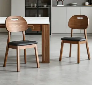 Two walnut-colored solid wood dining chairs with white PU soft seat cushions, hollowed-out backrests, suitable for home dining.