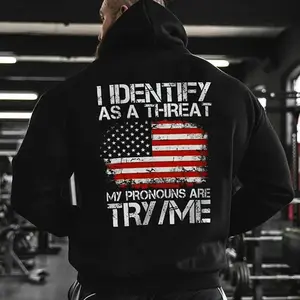 Unisex hoodie with “I identify as a threat” printed on it, featuring “My pronouns are try/me,” fleece-lined