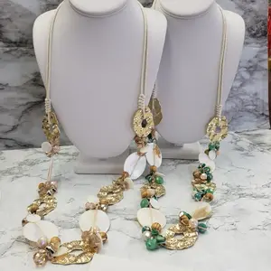 Odil Long Bohemian Style Statement Necklace with Textured Gold Tone Metal Disc White Shell Elements Green & Neutral Beads on Light-Colored Cord