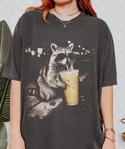 [ Sale Up To 40%] Comfort Colors  Raccoon Drinking Iced Coffee Shirt, Funny Animal Meme Tee, Coffee Lover Raccoon Shirt, Gift For Women and Man Unisex T-Shirt