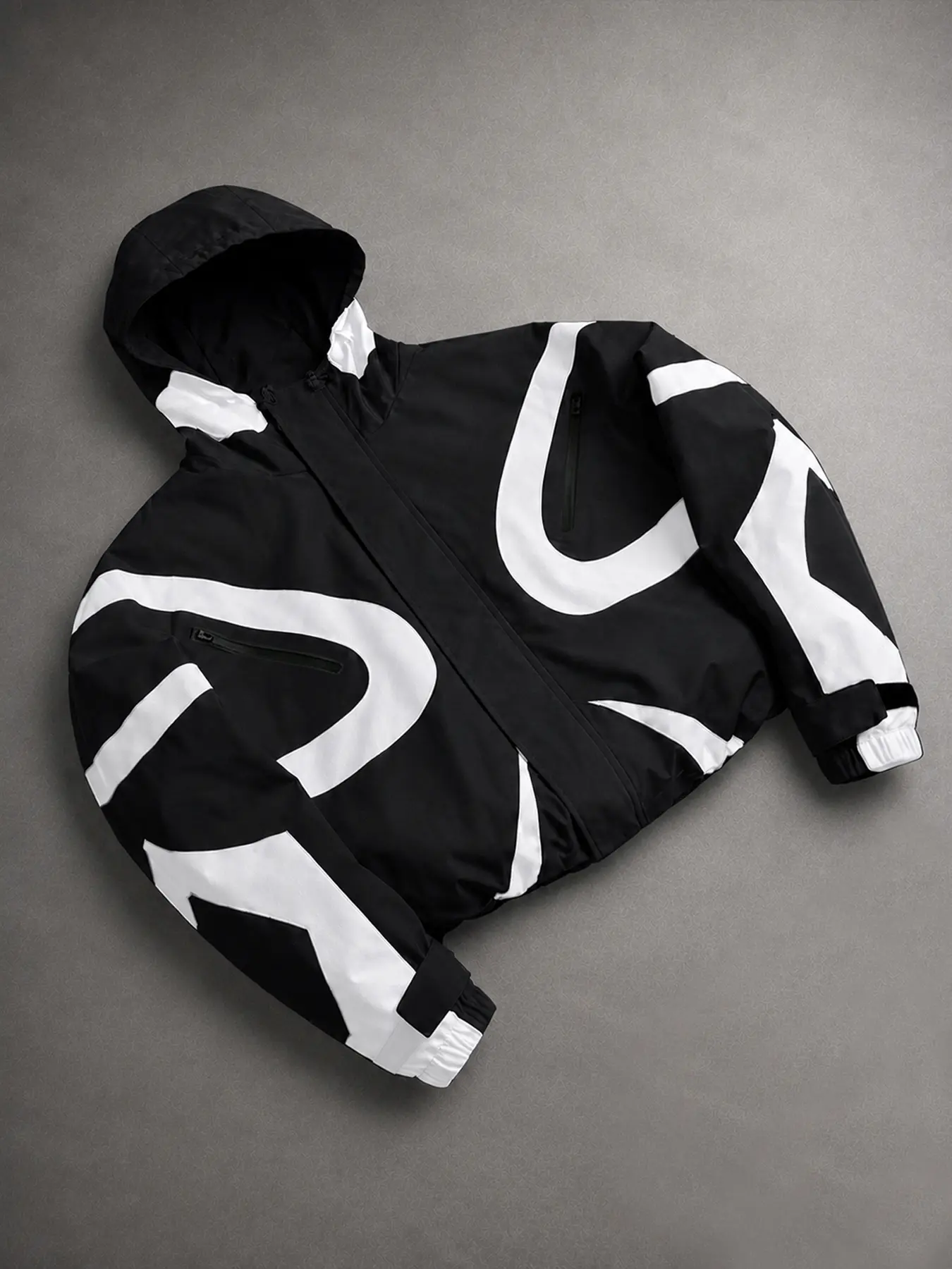 Men's hooded windbreaker jacket, perfect for back-to-school street style. Features a geometric patchwork design, zippered pockets, adjustable cuffs, and an adjustable hem.